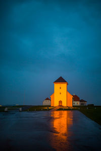 Illuminated building against blue sky at dusk