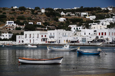 Boats moored in river by buildings in town