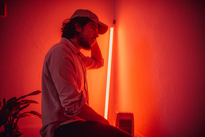 Side view of bearded man wearing cap in illuminated room