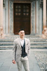 Portrait of young man standing in city