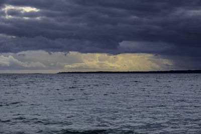 Scenic view of sea against storm clouds