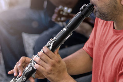 Midsection of man playing guitar