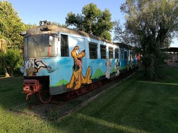 Train by railroad tracks against sky