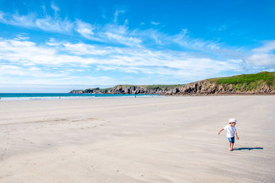 Full length of boy on beach against sky