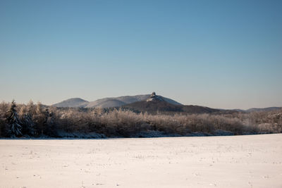 Scenic view of landscape against clear sky during winter