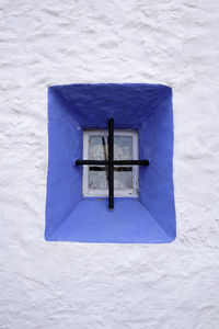 Close-up of cross against blue wall