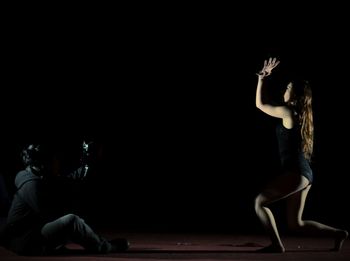 Man photographing woman dancing on stage