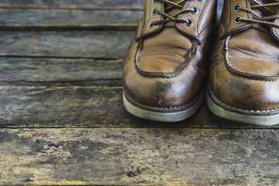 Low section of person wearing shoes standing on wooden table