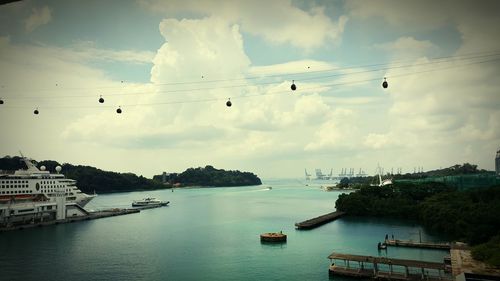 Bird flying over sea against cloudy sky