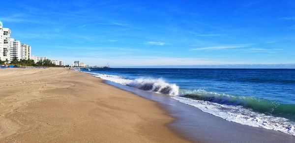 Scenic view of beach against blue sky