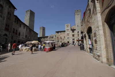 People on street amidst buildings in city