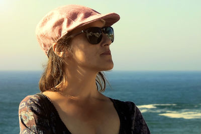 Portrait of woman wearing sunglasses against sea