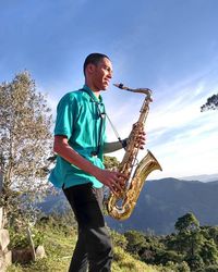 Full length of young man playing against sky