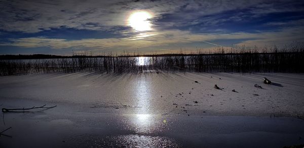 Scenic view of frozen lake against sky during sunset