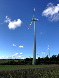 Low angle view of windmill on field against sky