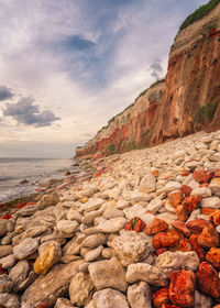 Rocks on beach against sky during sunset