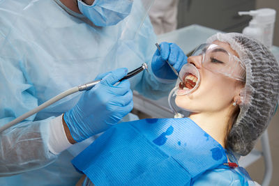 High angle view of dentist performing surgery patient in hospital