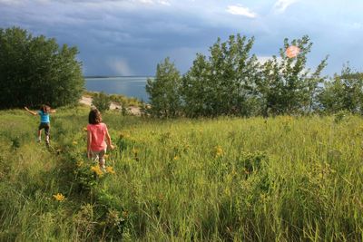 People on grassy field against sky