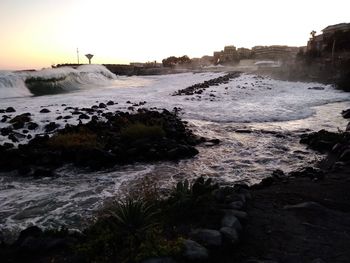 View of rocks in water at sunset