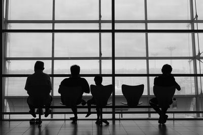 Rear view of silhouette people on window