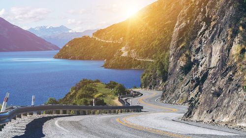 Scenic view of road by sea against sky