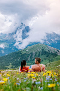 Rear view of people on mountain against sky