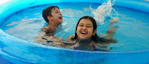 Playful siblings enjoying in swimming pool