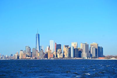 Skyscrapers in city against clear blue sky