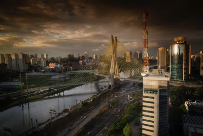 Illuminated cityscape against cloudy sky