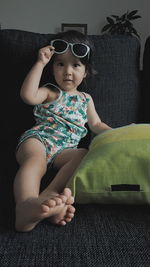 Cute girl sitting on sofa at home