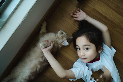 High angle view of girl playing with dog