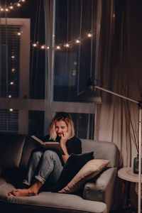 Woman sitting on sofa at home