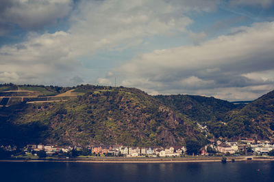 Scenic view of river and mountains against cloudy sky