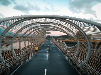 Arch bridge on footpath against sky