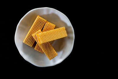 High angle view of bread in plate against black background