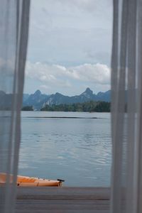 Scenic view of lake against sky seen through window