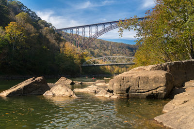 Arch bridge over river against sky