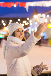 Portrait of woman photographing in city