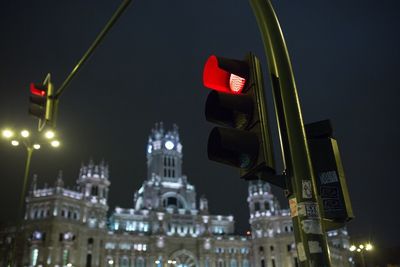 Low angle view of red light by plaza de cibeles at night