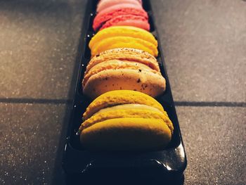 High angle view of multi colored macaroons in box on table