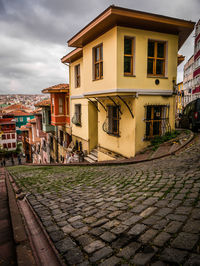 Street by buildings in town against sky