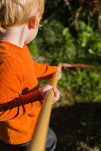 Boy holding rake in yard