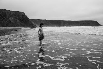 Shirtless boy standing at beach