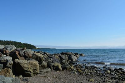 Scenic view of rocks on beach against sky