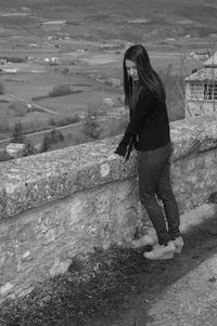 Side view of young woman standing on observation point