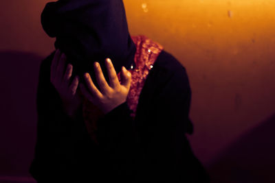 Close-up of silhouette hand on illuminated during halloween