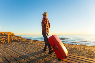 Boy on beach against clear sky