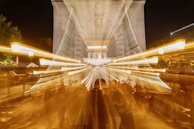 Digital composite image of illuminated bridge in city at night