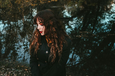 Full length of young woman standing in forest