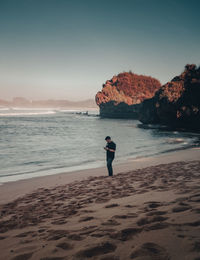 Man standing on beach against sky